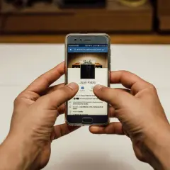 Ręce trzymają telefon z profilem FB. Chcesz wiedzieć, jak zmienić zdjęcie profilowe na FB, żeby nikt nie lajkował?