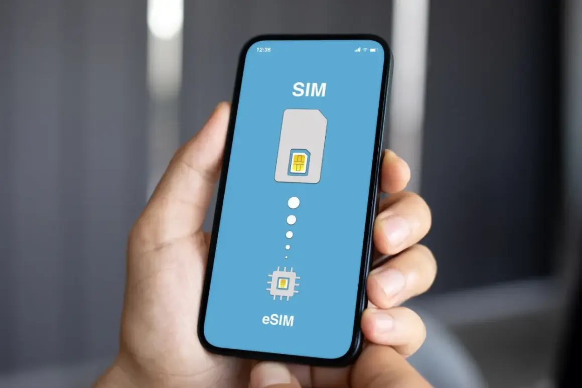 Dłoń trzyma smartfon z ekranem pokazującym przejście od tradycyjnej karty SIM do eSIM. Idealne rozwiązanie na kartę SIM internet za granicą.