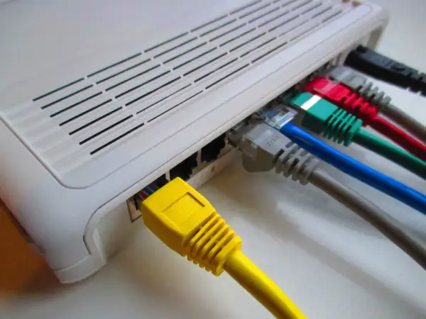 Router z wieloma kolorowymi kablami Ethernet. Stabilny internet po kablu to podstawa.