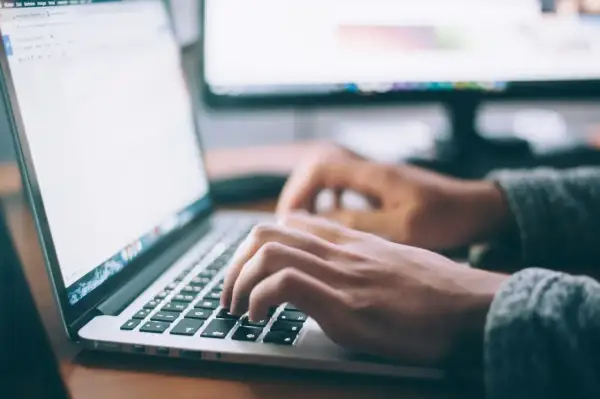 Dłonie piszą na klawiaturze laptopa, korzystając z szybkiego połączenia LTE do pracy zdalnej.